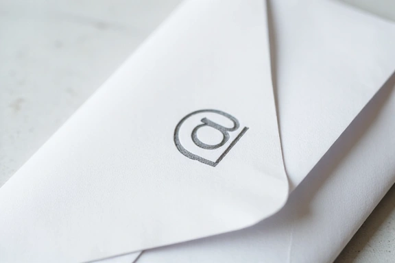 A pristine white envelope with a stylized email icon on it, symbolizing direct communication and messages.